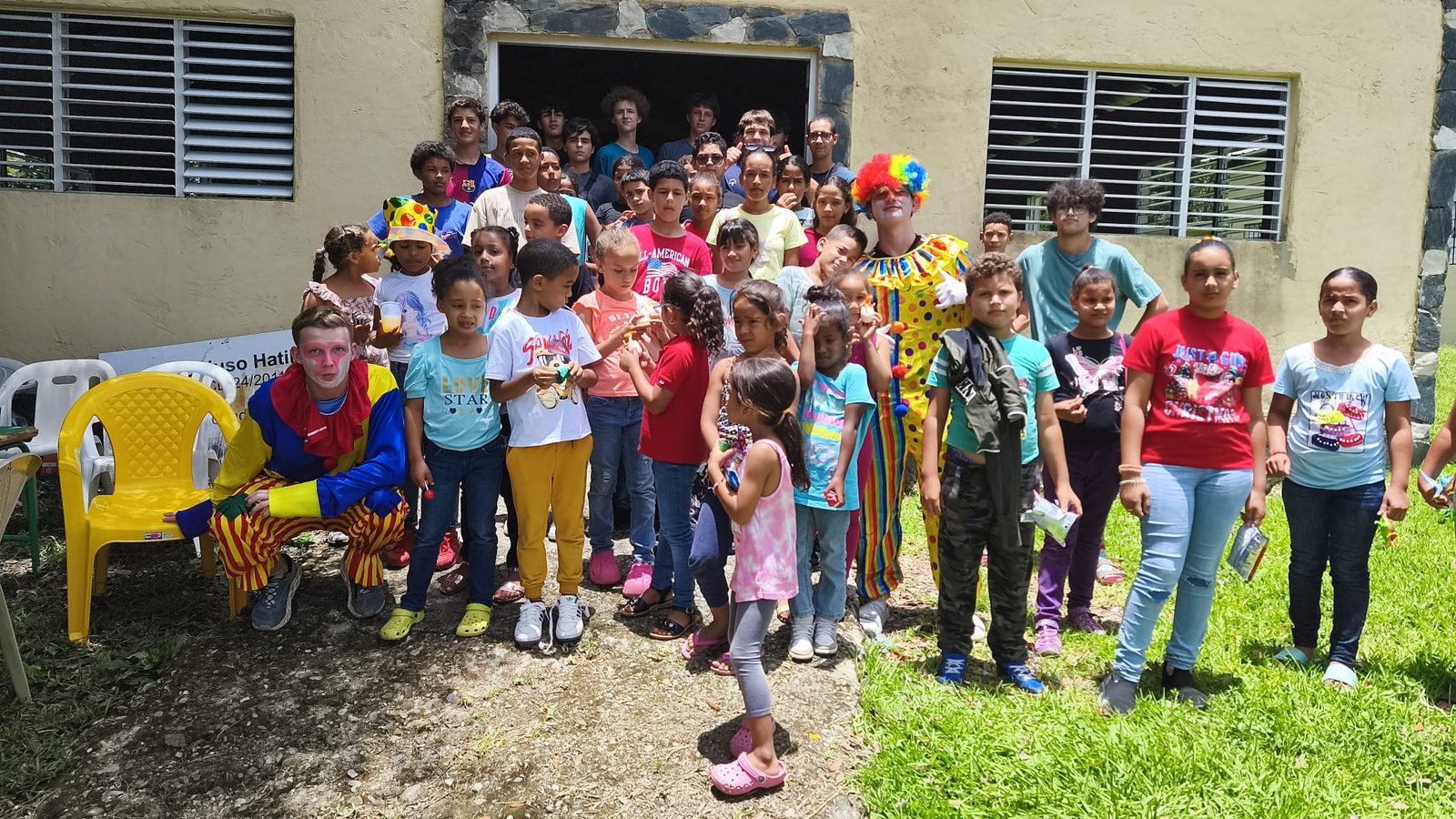 A group of children and volunteers gathered together at a community visit in the Dominican Republic